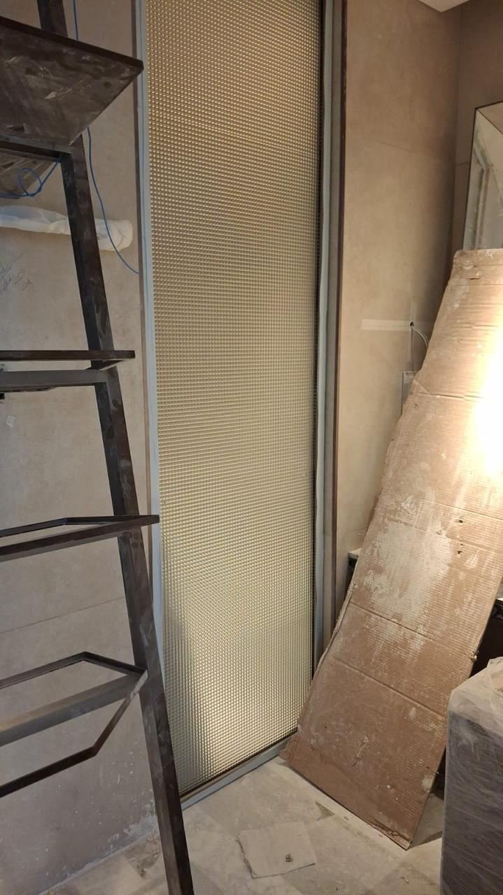 Glass partition installed near entrance mirror in guest bathroom