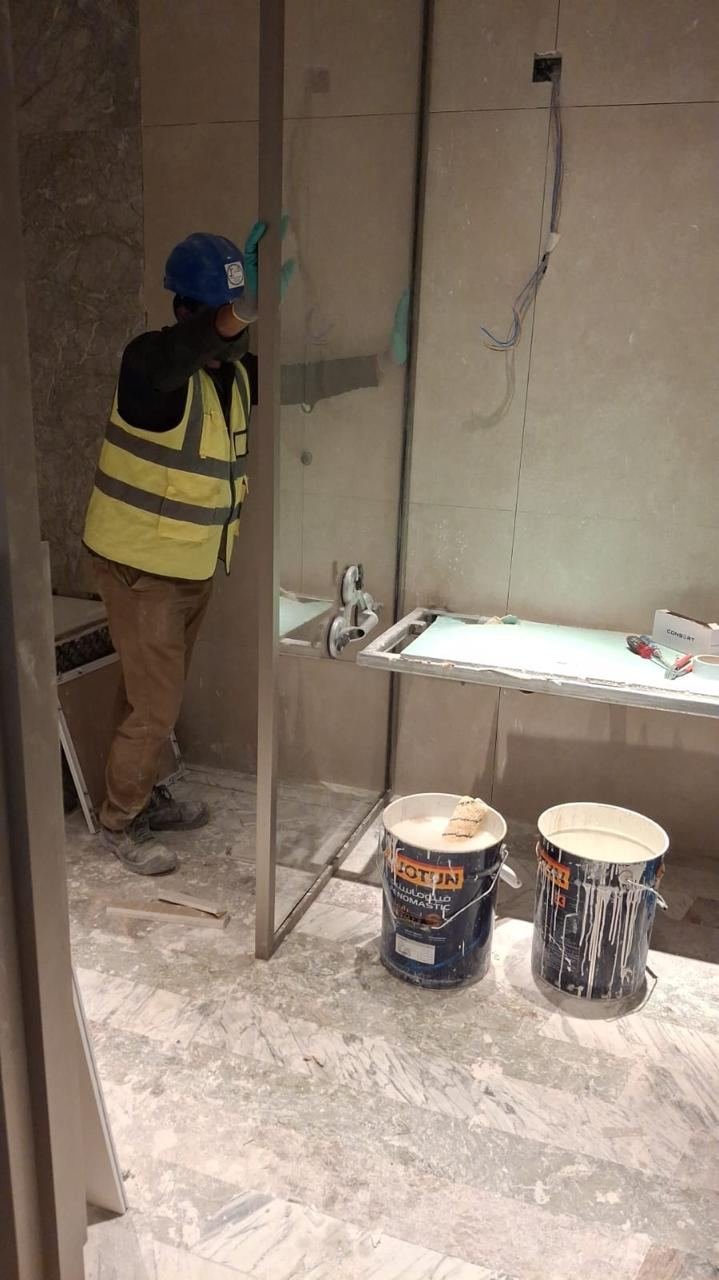 Installer fixing aluminium and glass panel on site at W Hotel KAFD